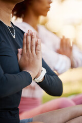 Women, namaste hands and yoga meditation at park, wellness and freedom of chakra energy, zen fitness or peace. Closeup of calm friends, relax exercise and meditate in nature for mental health balance