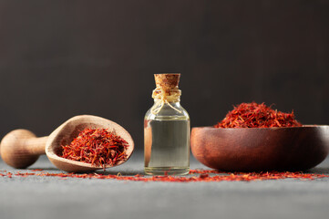 Glass bottle of saffron essential oil with dried saffron, spice or herb oil concept, alternative...