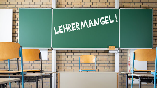 LEHRERMANGEL an deutschen Schulen - Tafel , Tisch und Stühle in einem leeren Klassenzimmer, mit deutschem Text