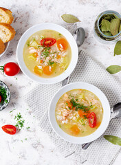 Fish soup with salmon, vegetables and rice in white bowl. Top view, above