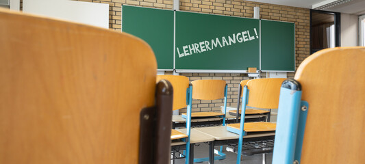 LEHRERMANGEL an deutschen Schulen - Tafel , Tisch und Stühle in einem leeren Klassenzimmer, mit...