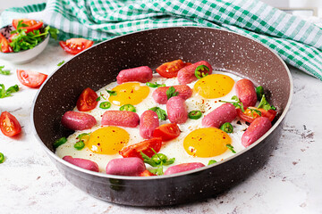 Homemade delicious american breakfast with  fried eggs,  sausages, and tomatoes. Concept of a healthy lifestyle