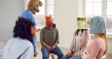 Group of funny people in animal disguise having a meeting in the office. Team of young men and...