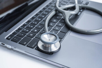 grey Stethoscope on laptop or on the keyboard of pc, close-up. macro view of a grey stethoscope on a business office laptop keyboard with selective focusing effect