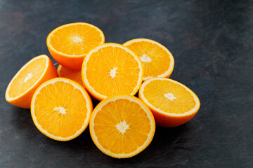 Fresh orange halves on a dark background. Juicy citrus fruits for making juice