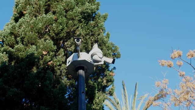 CCTV camera on the street in the park. The concept of security in the city.