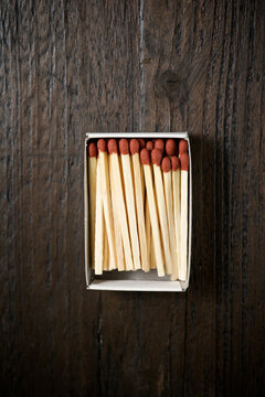 Overhead view of matchsticks in box on wooden table