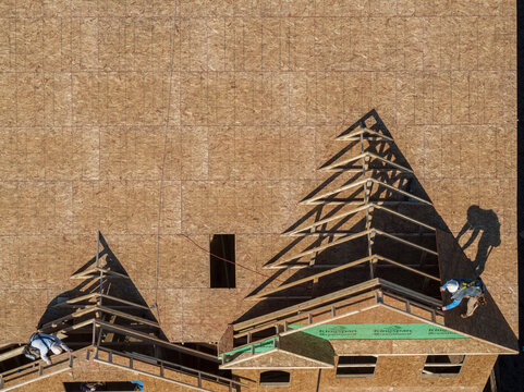 Two workers working on top of house roof, Lilburn, Georgia, USA