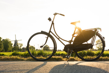 Vintage and black bicycle standing on road at sunset, Groningen, Netherlands
