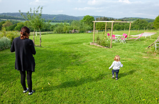 a little boy and his mom having fun on a green field in the country side, Caurel Brittany, France.