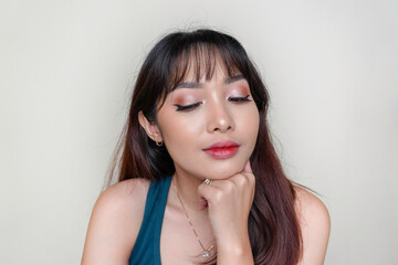 A beauty cheerful face of Asian young model wearing teal green top. Makeup skincare beauty facial treatment, spa, female health concept.