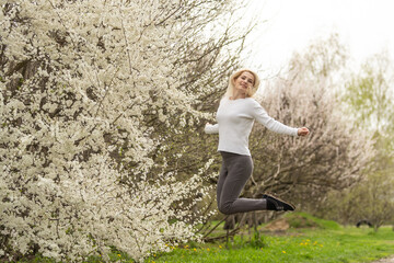 beautiful young woman in blooming cherry blossoms garden.