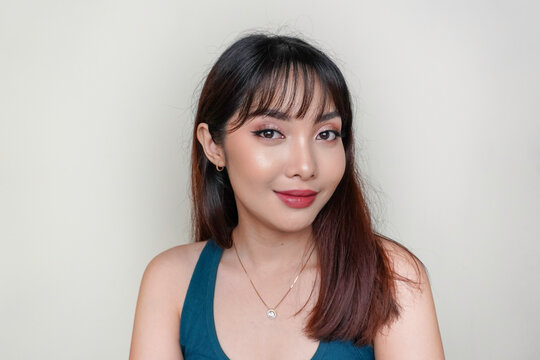 A beauty cheerful face of Asian young model wearing teal green top. Makeup skincare beauty facial treatment, spa, female health concept.