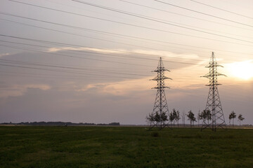 Power lines against the sunset sky. Power line towers. - 559116068