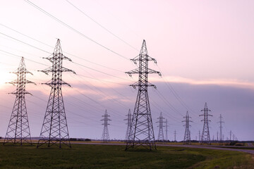 Network of power lines against the backdrop of the sunset sky. Power line towers. - 559116074