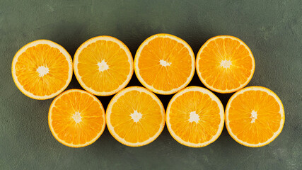Halves of juicy oranges on a green background. Half cut oranges for making juice. Close up