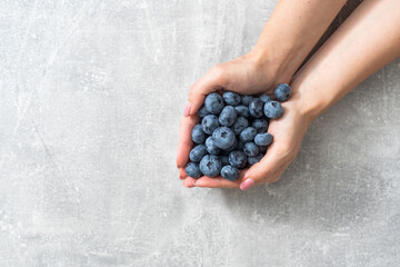 Close-up of hands holding blueberry. Harvest, summer, healthy eating concept.