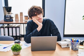 Young hispanic man business worker tired using laptop at office