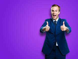 Happy excited businessman showing two thumbs up like hand gesture, in blue confident suit, over...
