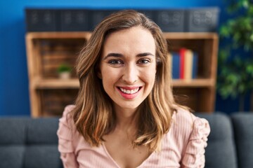 Young woman smiling confident sitting on sofa at home