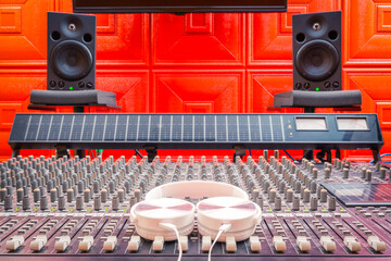 white headphone on audio mixing console, studio monitors background. recording and music production...