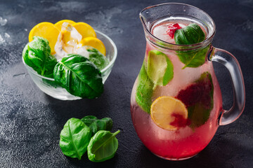 Strawberry basil lemonade iced jug pitcher over dark backdrop