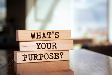 Wooden blocks form the words 'What's your purpose?' on blur background.
