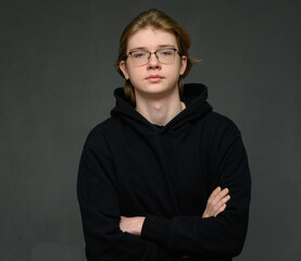 Caucasian guy portrait stands on a gray background calmly looking at the camera