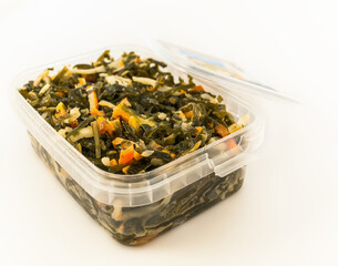 seafood salad with laminaria seaweeds and calamaries packed plastic container, isolated