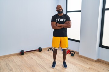 African american man working at fitness gym happy face smiling with crossed arms looking at the camera. positive person.