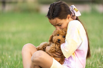 Little girl with a maltese puppy, outdoor summer.