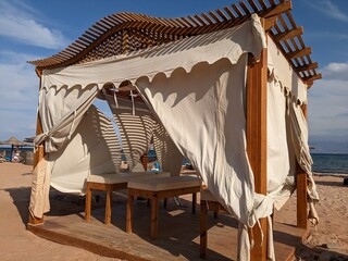 wooden tent with curtains for massage on the seashore