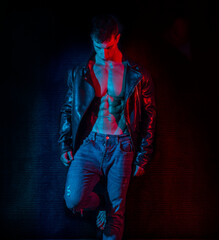 Muscular bodybuilder opening leather jacket on naked muscle torso