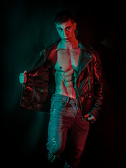 Muscular bodybuilder opening leather jacket on naked muscle torso