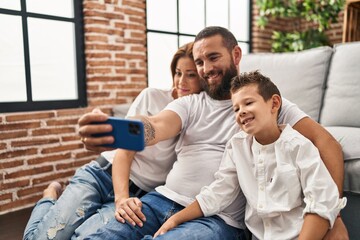 Family make selfie by smartphone sitting on floor at home