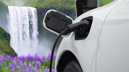 Electric car charging energy from charging station in the natural scenery, waterfall and stream...