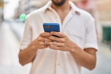 Young arab man using smartphone at street
