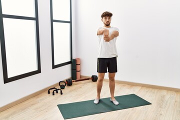 Young arab man stretching at sport center