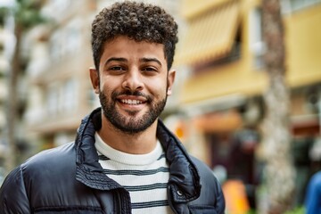 Young arab man smiling outdoor at the town