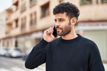 Young arab man smiling confident talking on the smartphone at street