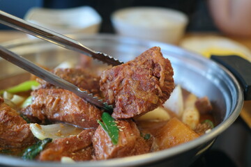 Pork spareribs seasoned and braised in a little broth with chili peppers, chestnuts, carrots and Korean dates
