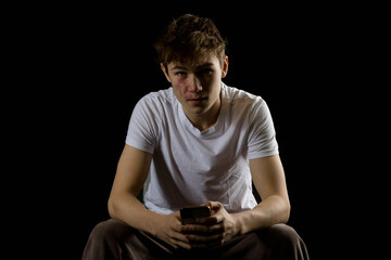 Portrait of a 17 year old boy on a black background