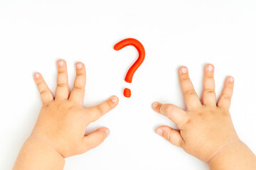 Child hands playing with red question mark sign of plasticine on white background. FAQ and help concept.