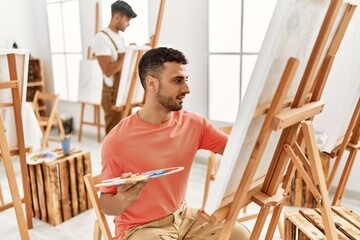 Two hispanic men couple smiling confident drawing at art studio