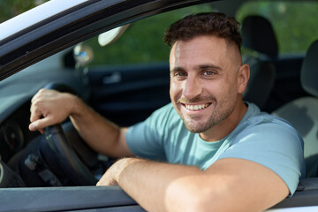 Fototapeta na wymiar Young hispanic man smiling confident driving car at street