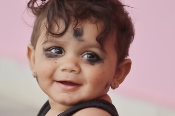 Close-up photo of Beautiful little indian hindu baby smiling looking at the camera