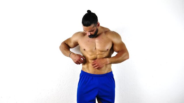Fit, athletic muscular man pinching his stomach skin