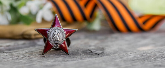 St. George's ribbon and the Order of the Red Star of the USSR World War II veteran on a wooden...