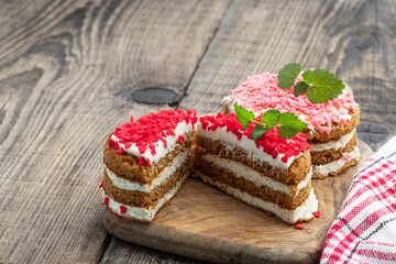 Homemade layered dessert with whipped cream and heart shaped sprinkles on wooden table