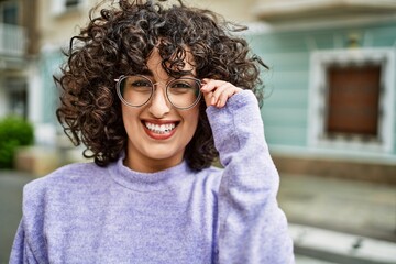 Young middle east woman smiling confident wearing glasses at street